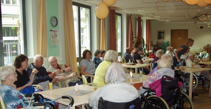 Speisesaal mit vielen älteren Menschen und Sektgläsern