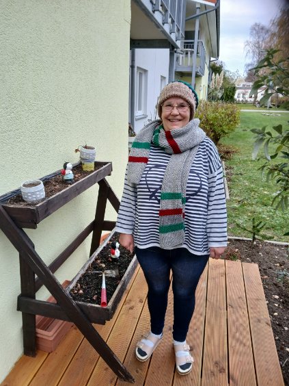 Bewohnerin freut sich über selbstgestrickten Schal und Mütze